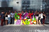 Collaborateurs en train de bomber une fresque collective lors d’un atelier MadCityZen. | © MadCityZen